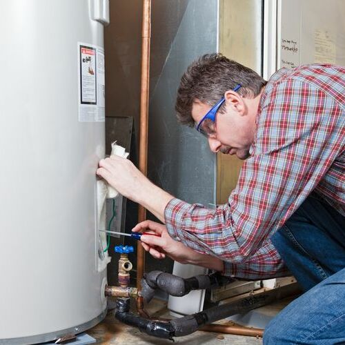 A Plumber Works on a Water Heater.