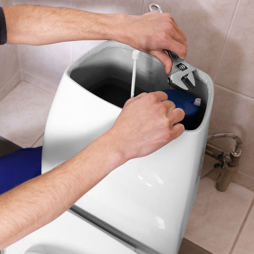 Plumber repairing toilet cistern